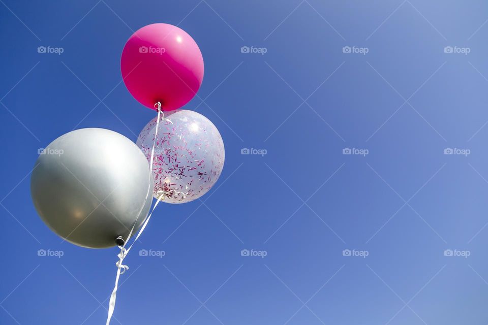 Three helium balloons in the sky