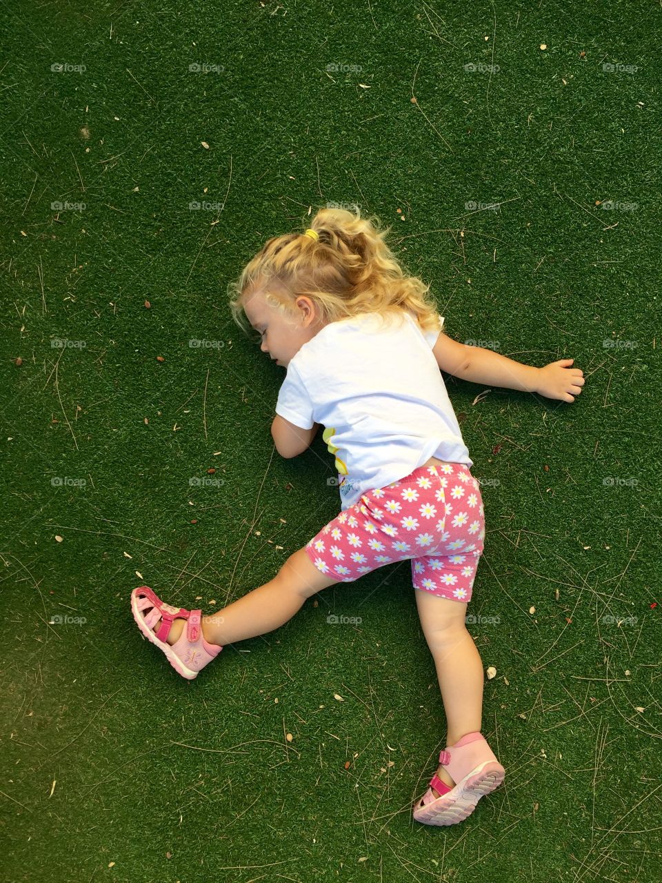 Elevated view of a little girl sleeping on grass in park