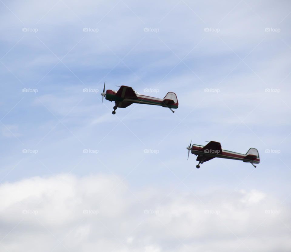 The plane is flying against the blue sky. Aerobatic figure, military aircraft.