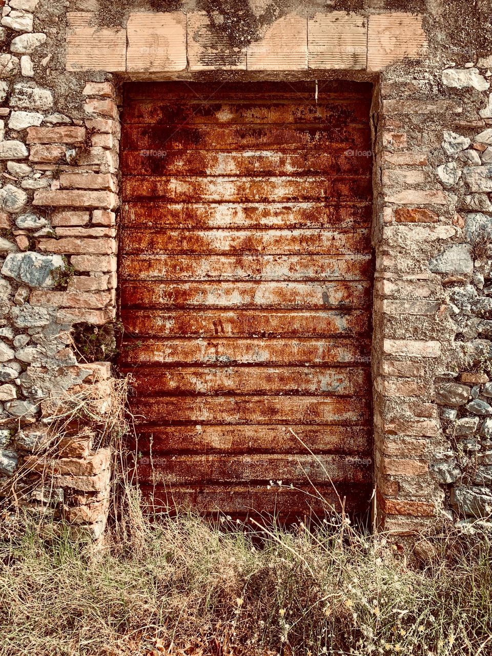 a closed shutter of an old shop, symbol of a changing economy