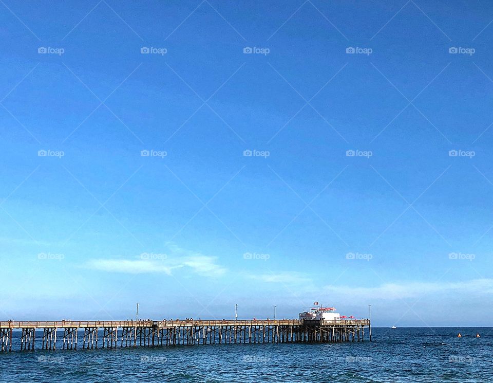 Capture of the Balboa Pier in Newport Beach, CA with a calm tide and clear sky. 