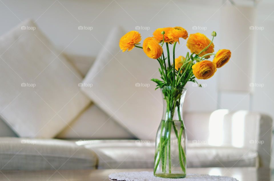 Top view of yellow blooming flowers in a vase at cozy home close up. Ranunculus.