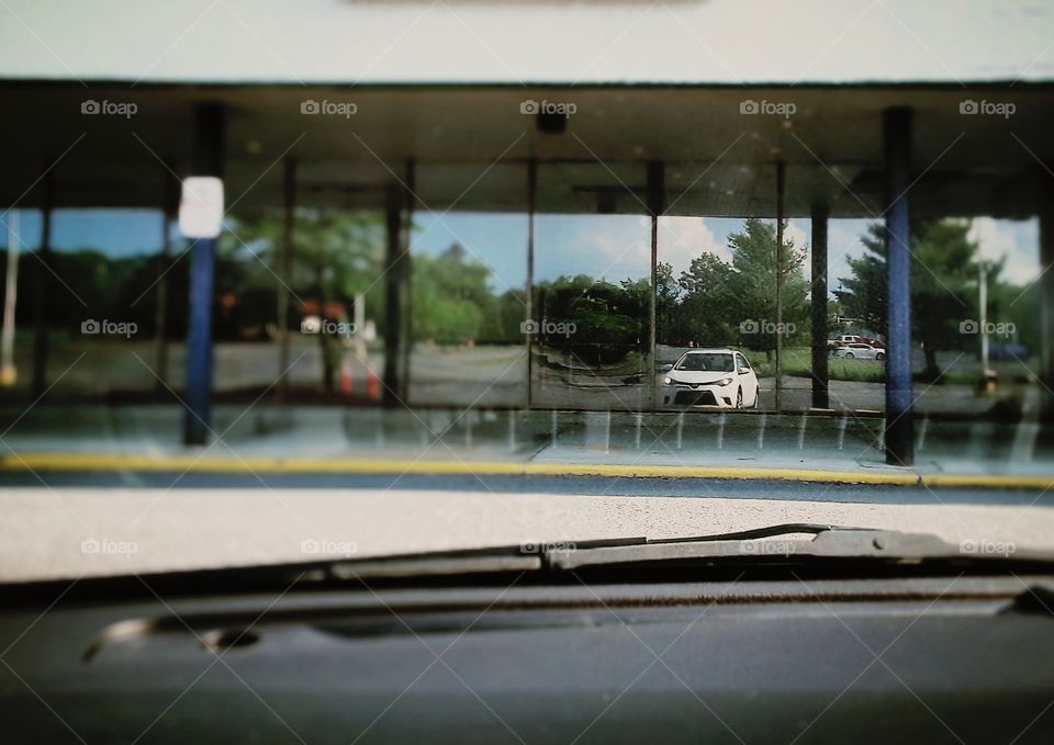 Reflection of white Corolla in store window