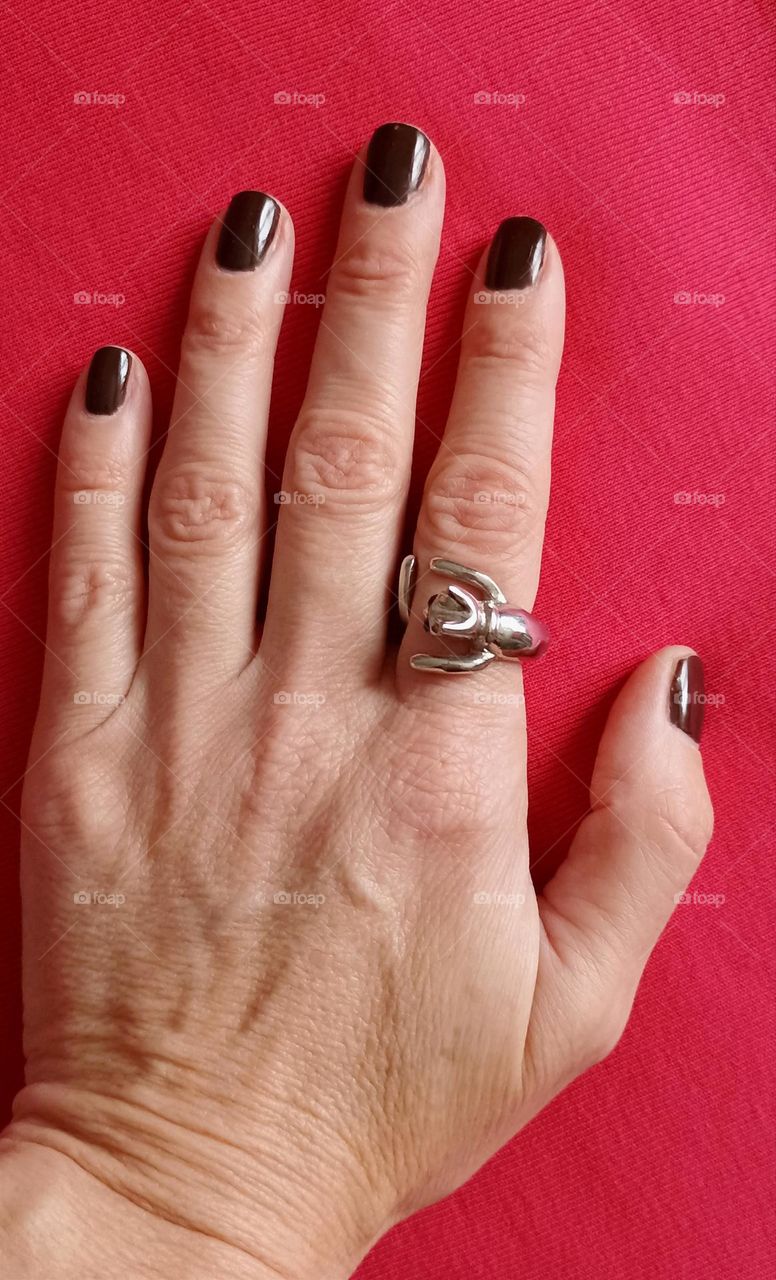 female hand with manicure red background