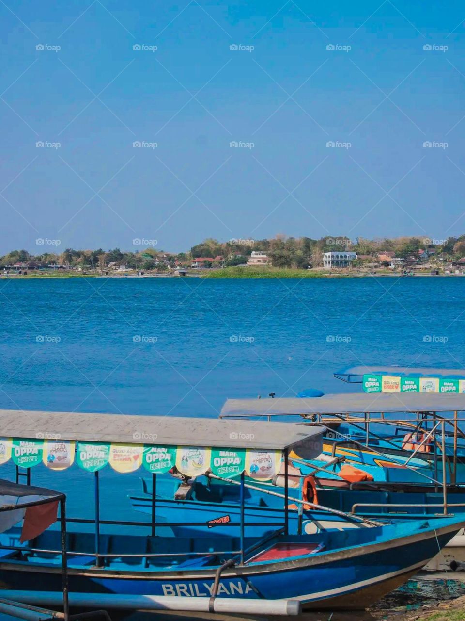 Portrait of several boats parked at the pier with a lake and natural scenery in the background