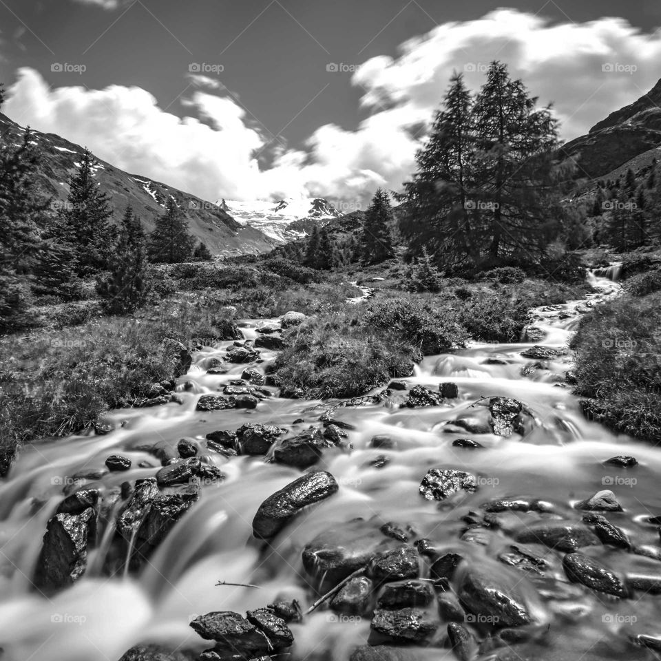 Towards the valley. Streams of water that arise from the glacier and meet on the slopes of the mountain and then, united, descend towards the valley.