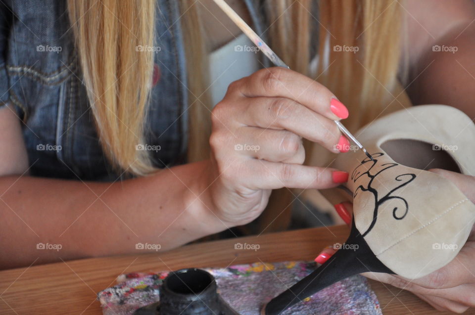 woman painting on shoe