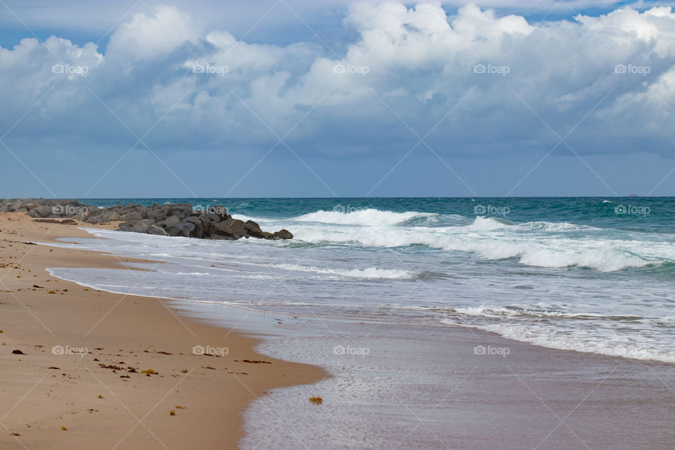 Beautiful waves on a sandy beach in cloudy weather