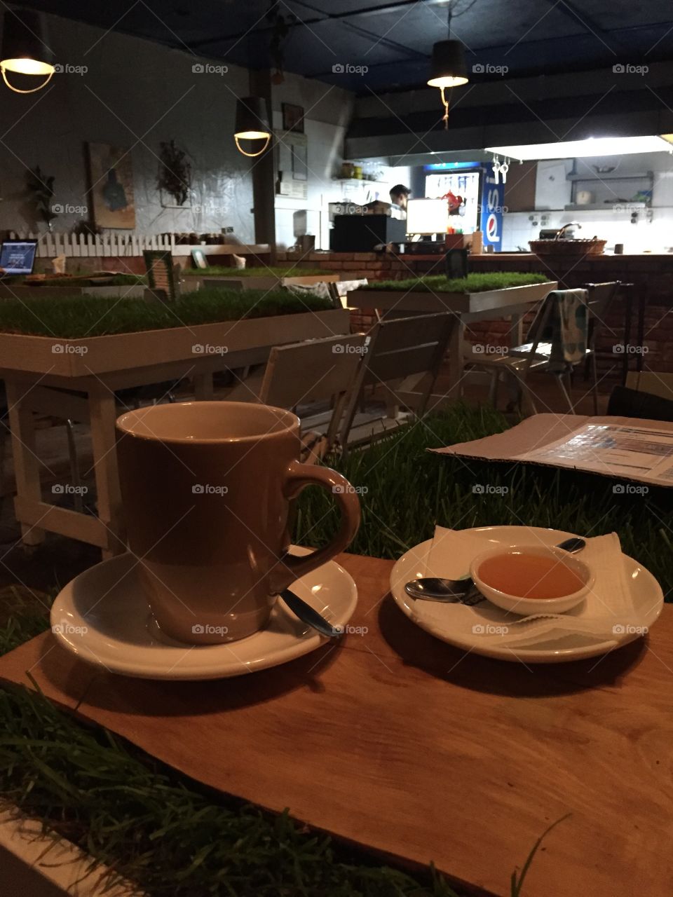 Tea cup with honey on a wooden tablet in a cafe