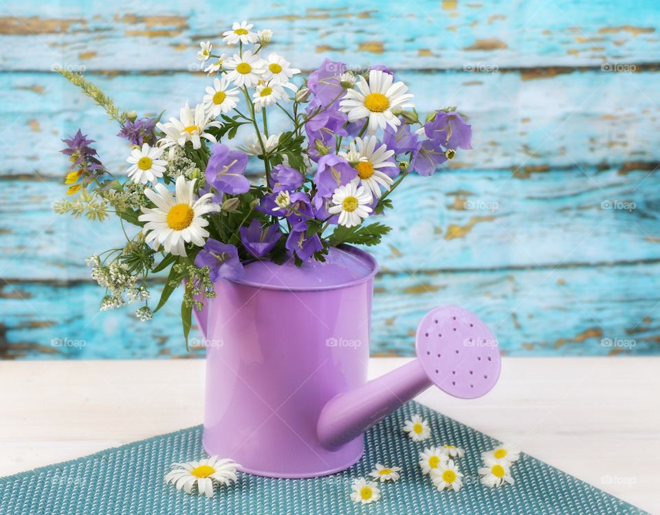 summer wild flowers in a purple watering can