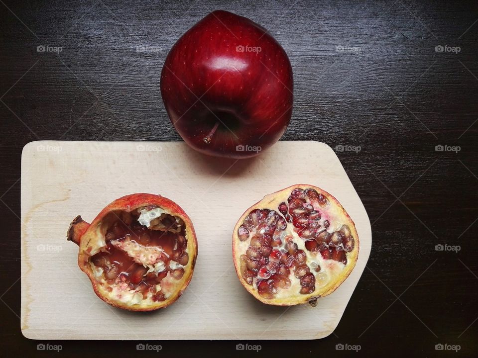 Red apple and pomegranate on table