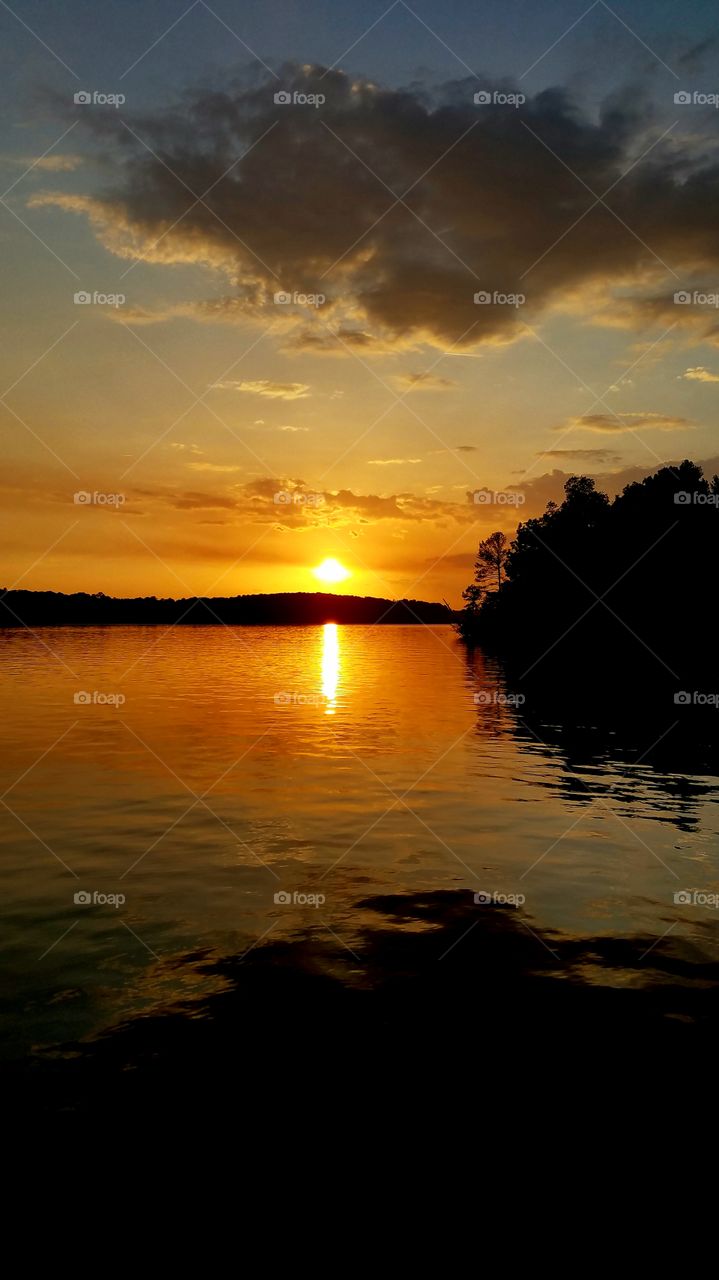 orange sunset reflected on smooth waters.