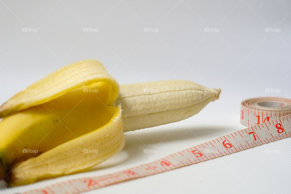 Penis size concept using banana, soft measuring tape