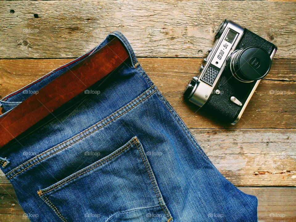 blue jeans with leather belt and old film camera