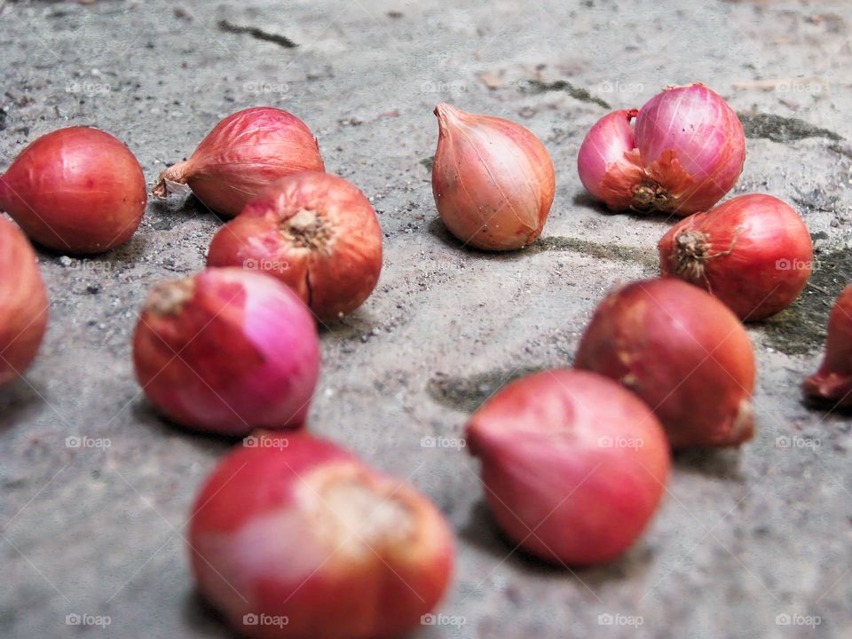 Close-up of raw shallots messy on the ground