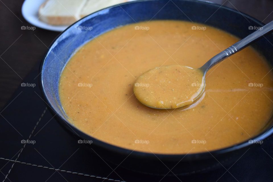 Vegetable soup on spoon in a bowl.  Healthy and dietary food concept.