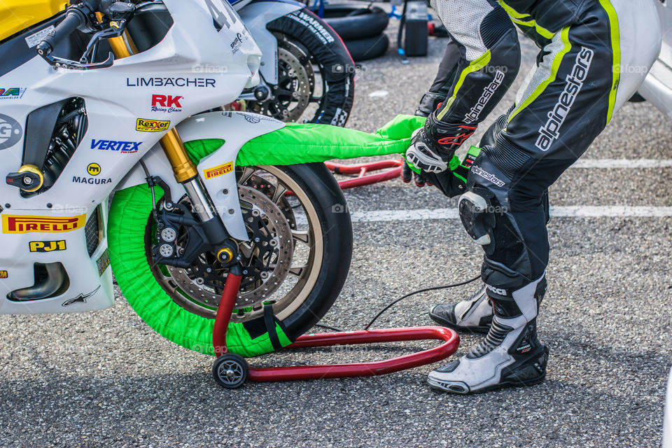 motorcycle driver at the competition draws heating blankets from the tires