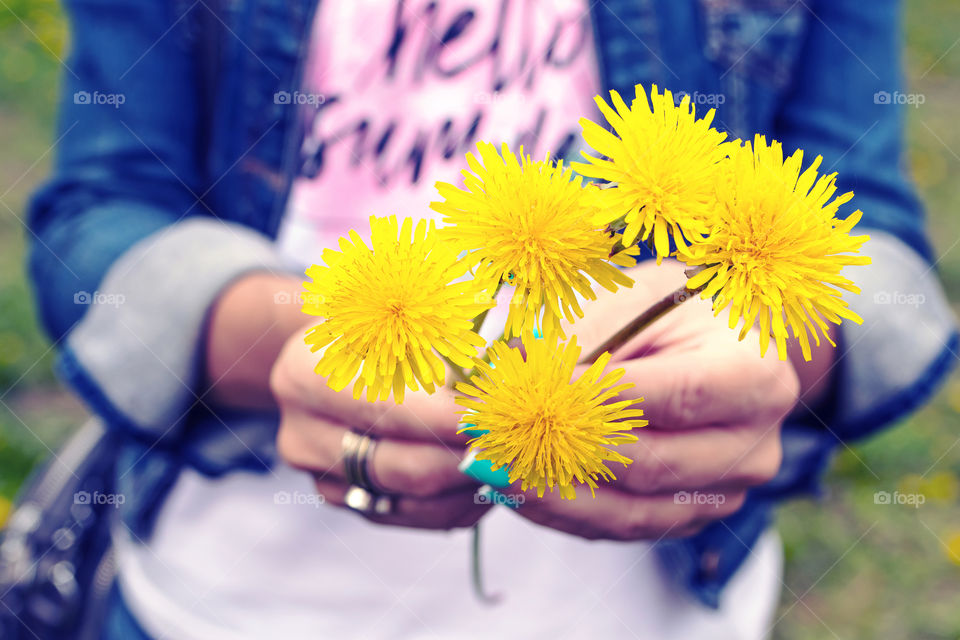Girl holding a yellow dandelion