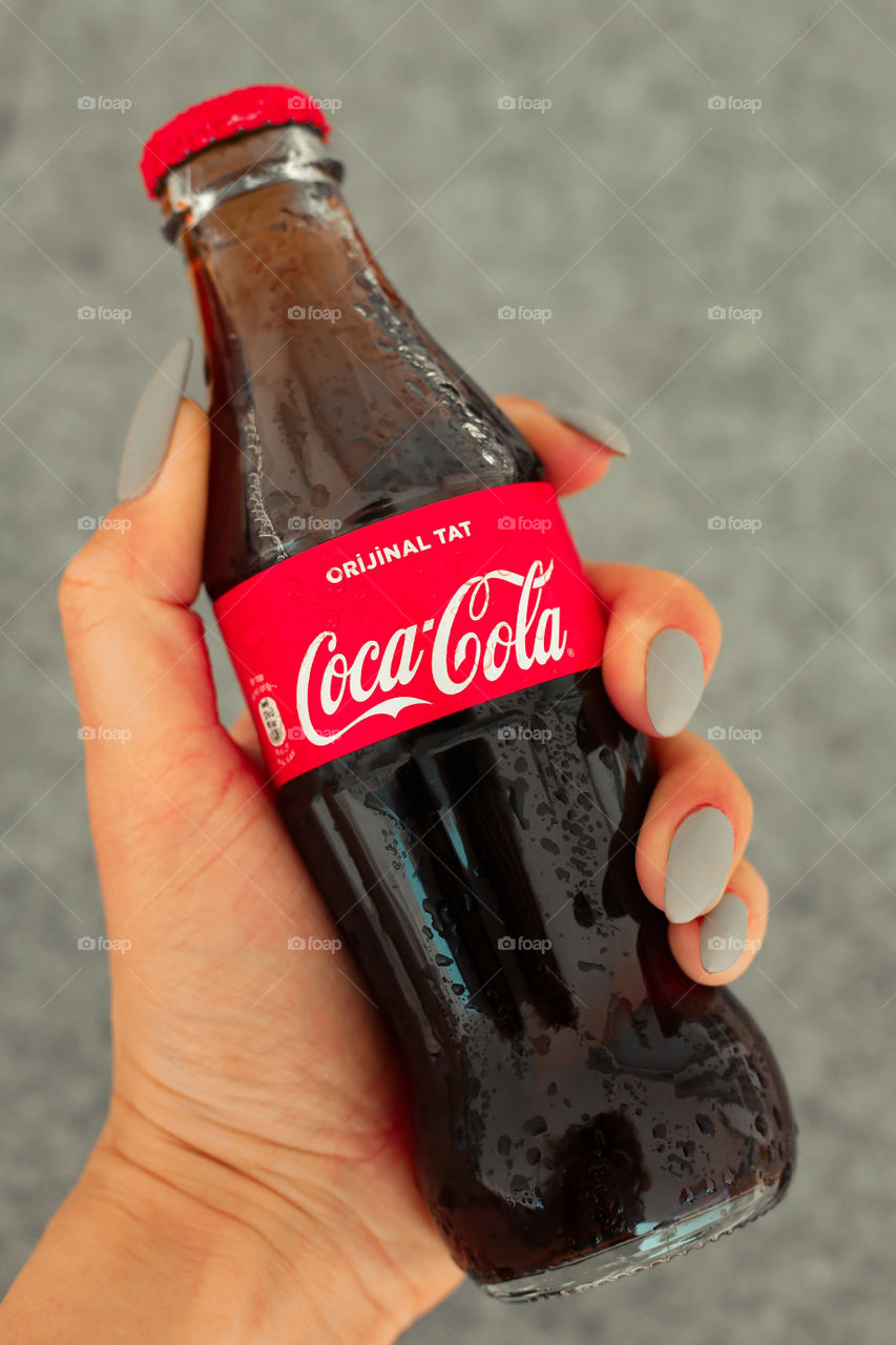 Bottle of Coca Cola in hand
