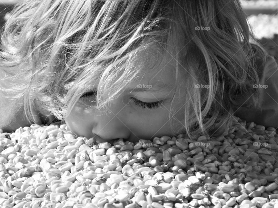 Little girl lying on corn seed