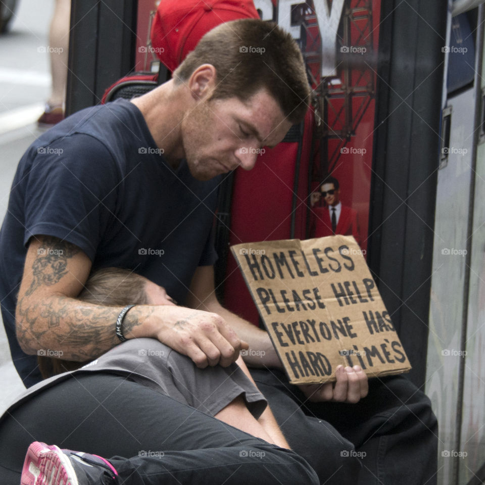 Homeless man holding up sign in New York City, homeless girl sleeping 