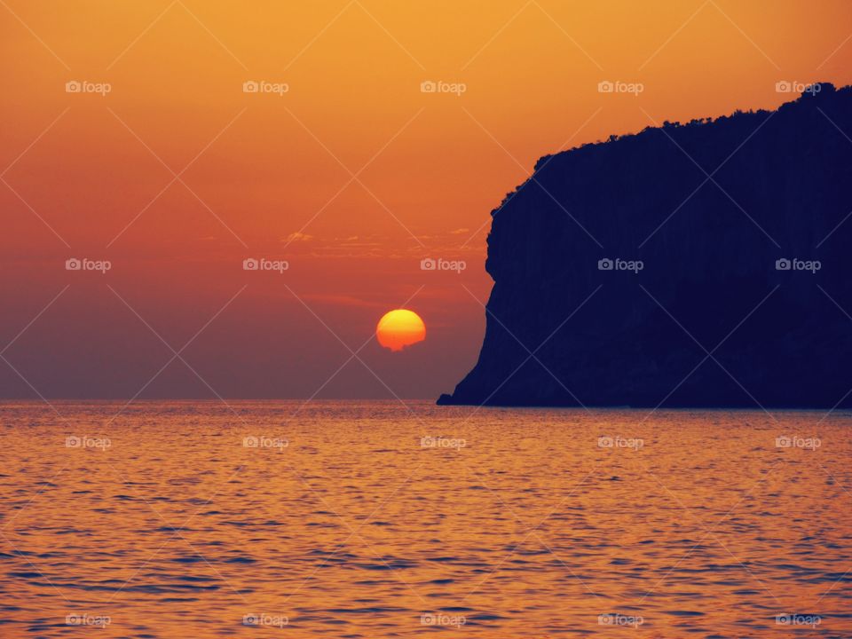 Sun goes down  near  Islet of Dino ( Italy ).