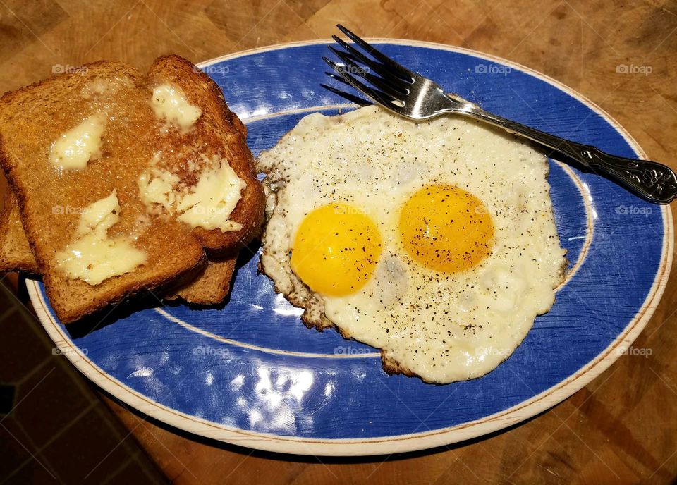 Sunny Side Up eggs & toast just buttered. Good asting breakfast. Great breakfast with added ground pepper.
