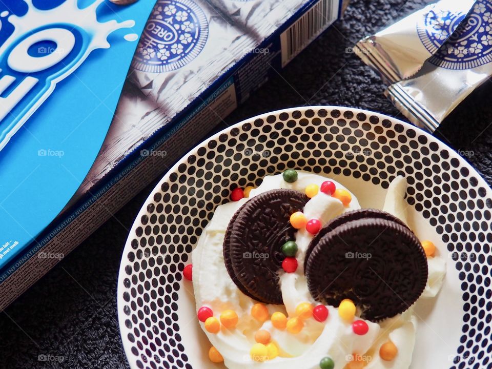 Oreo cookies with whipped cream and sprinkles.