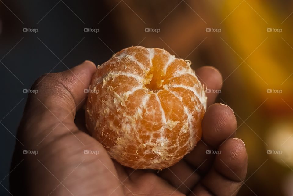 Person holding orange fruit