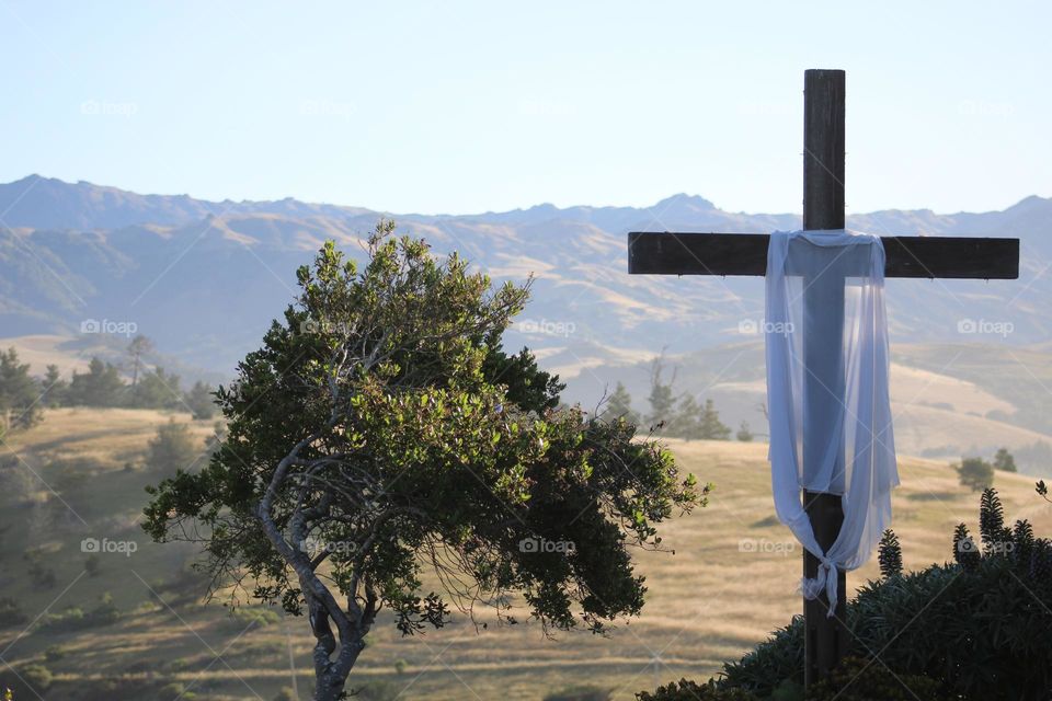 The Beauty of Faith: a lone cross, draped in white, watching over the countryside.