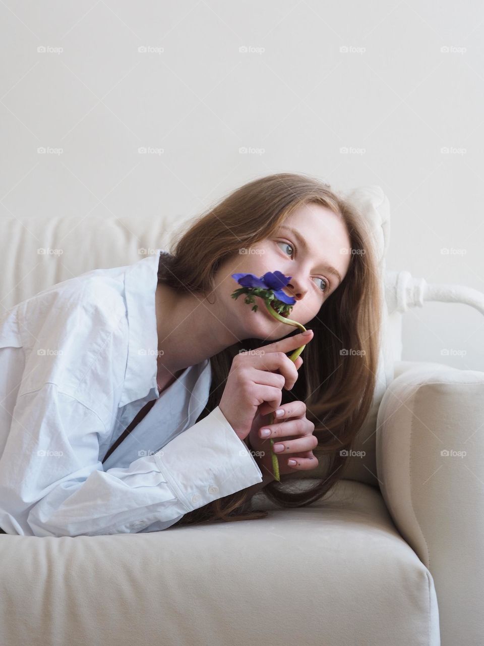 Young beautiful girl with long hair lies on a sofa, portrait of girl 