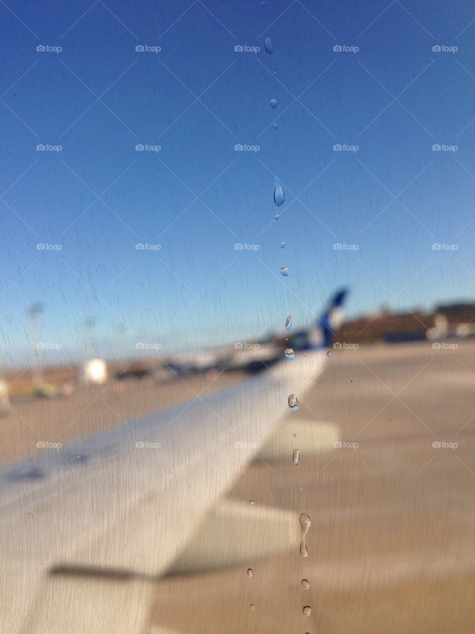 Gota d'agua sob a janela do avião.