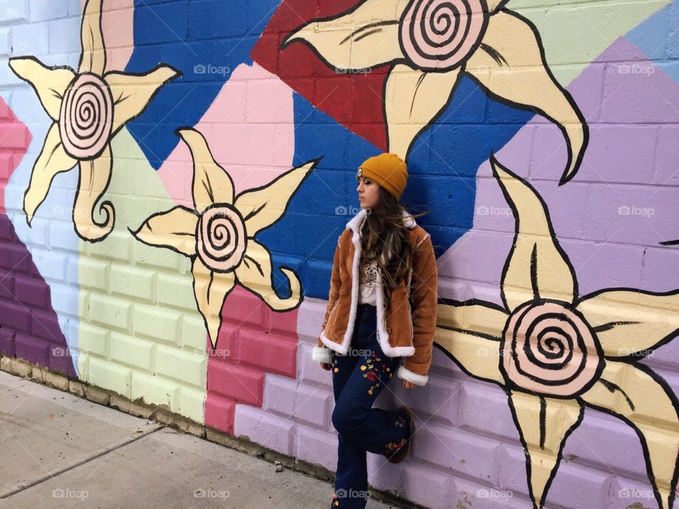 This photo features a young woman leaning against one of the many murals that fill Pittsburgh’s streets. 