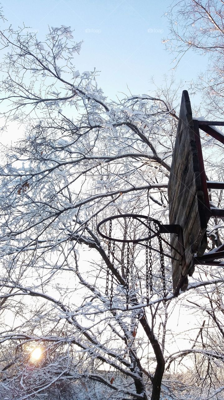 Old wooden and metal basketball hoop in the yard in winter