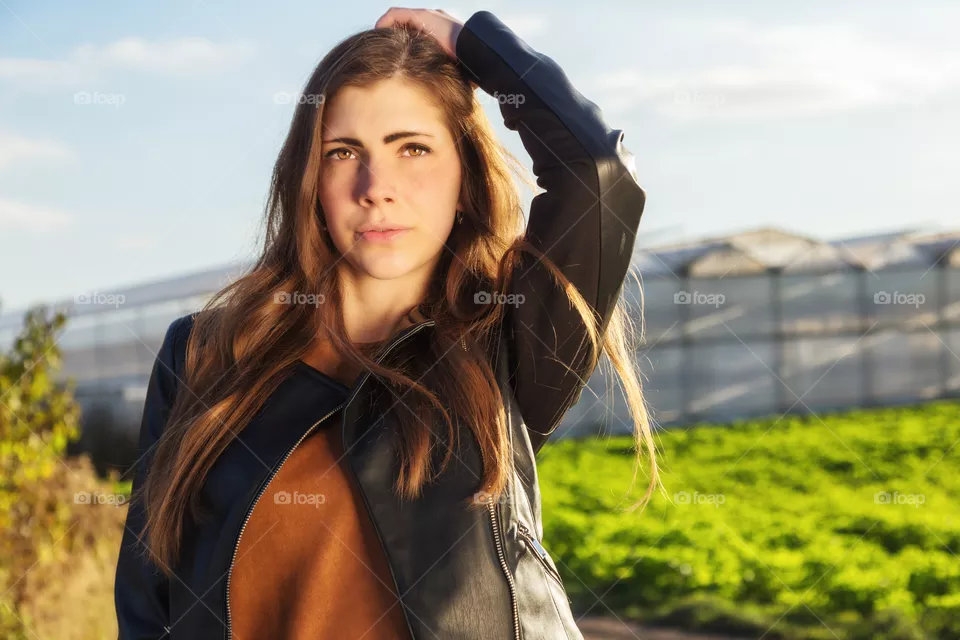 A young brunette woman is posing in the camera