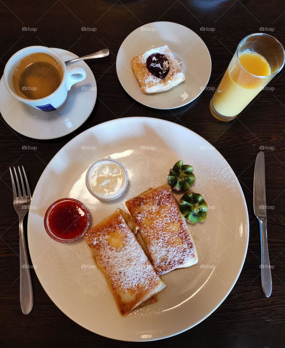 Tasty and delicious breakfast. Orange juice, coffee, pastry and pancakes with kivi, jam and sour cream. Good appetite!