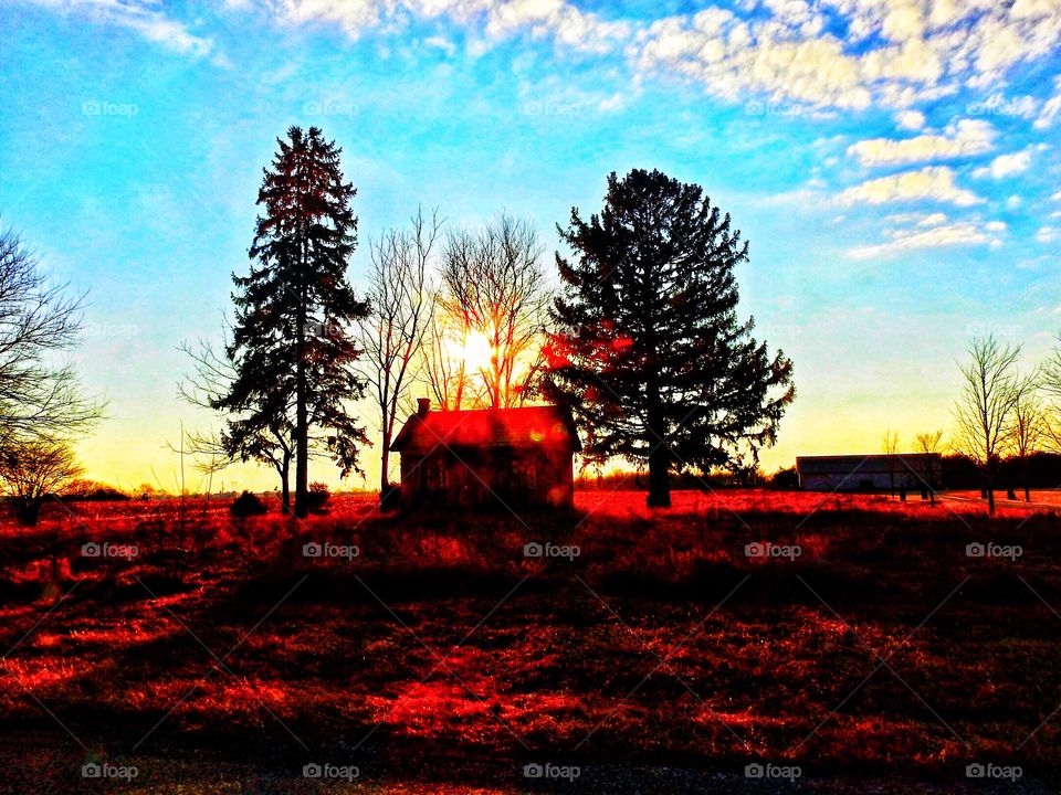 Sunset behind the tiny old home in central Indiana on a winter day 