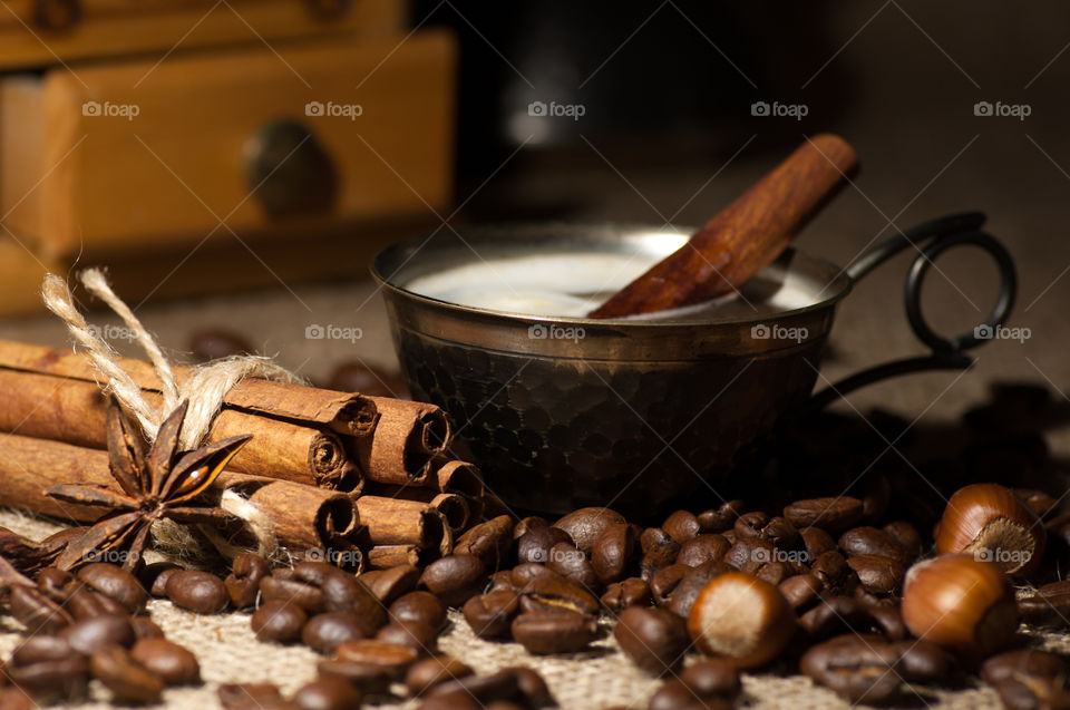 Coffee in vintage cup served with cinnamon, anise star and coffee beans