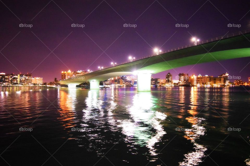 Illuminated bridge over river at night