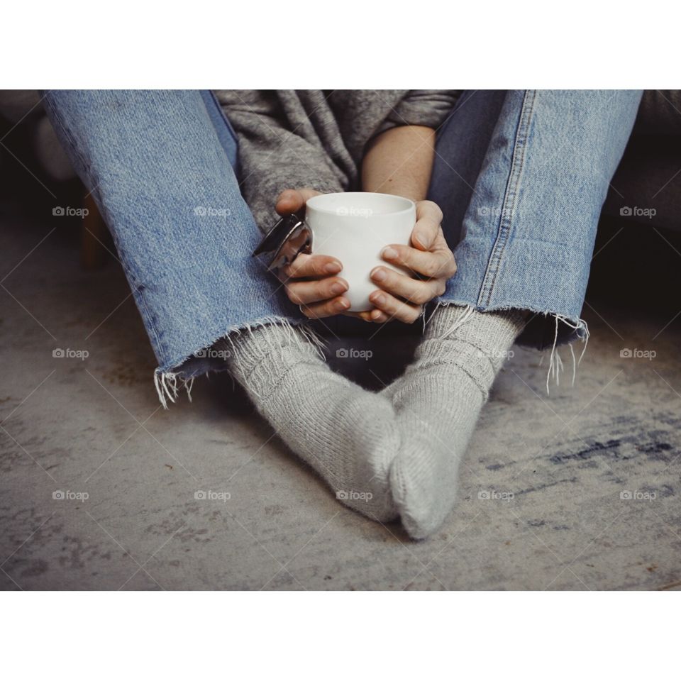Warming up with a nice cup of hot tea while wearing hand knitted woolen socks. 