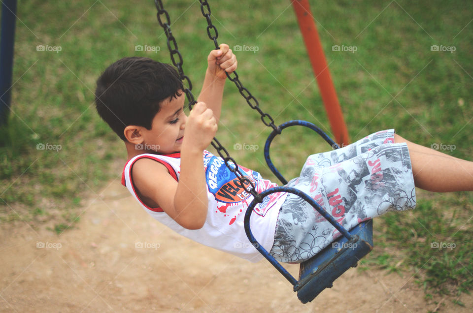Little boy enjoying swing in park