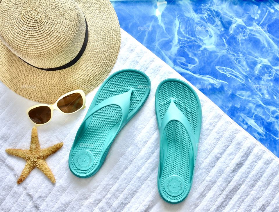 Flat lay summer theme, flip flops, sunglasses, hat, starfish, beach towel still life 