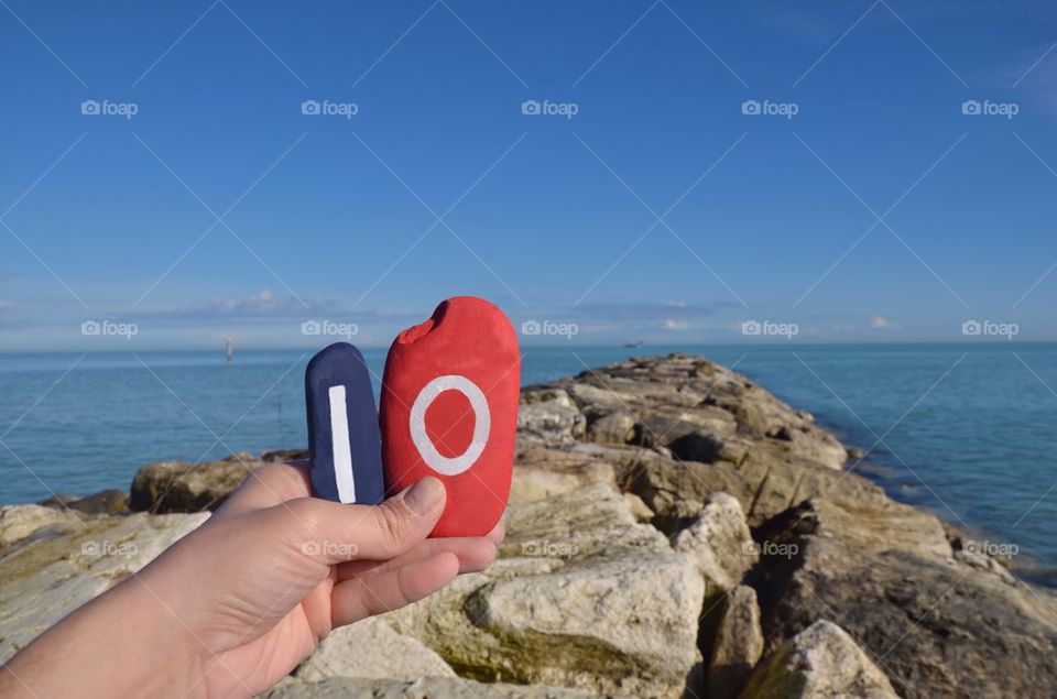 Io, egoism on stones with sea background