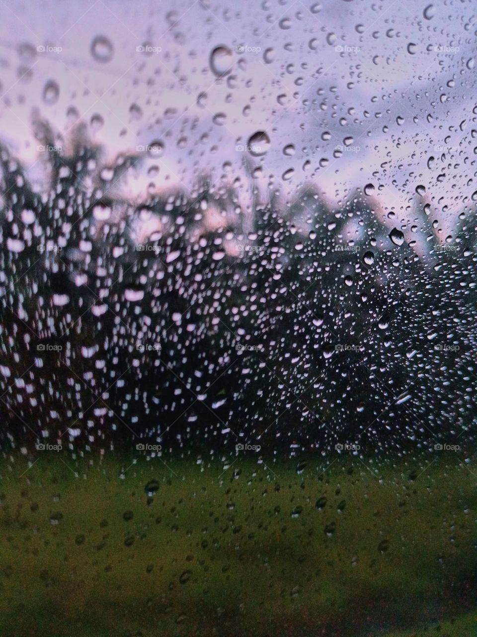 Selective focus on the rain drops on the windshield of the car. After rain at the rainy season