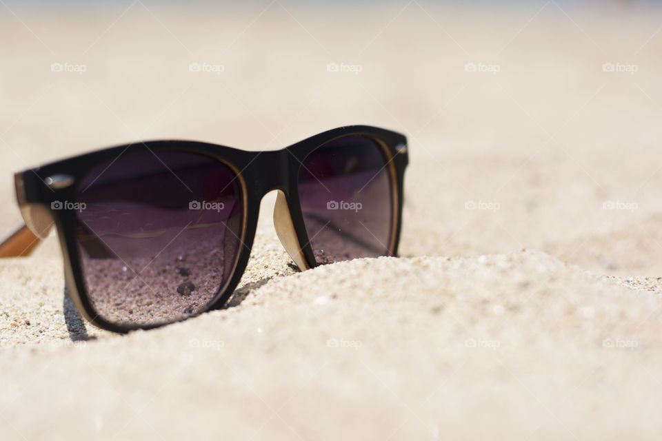sunglasses on sand. sunglasses on sandy beach
