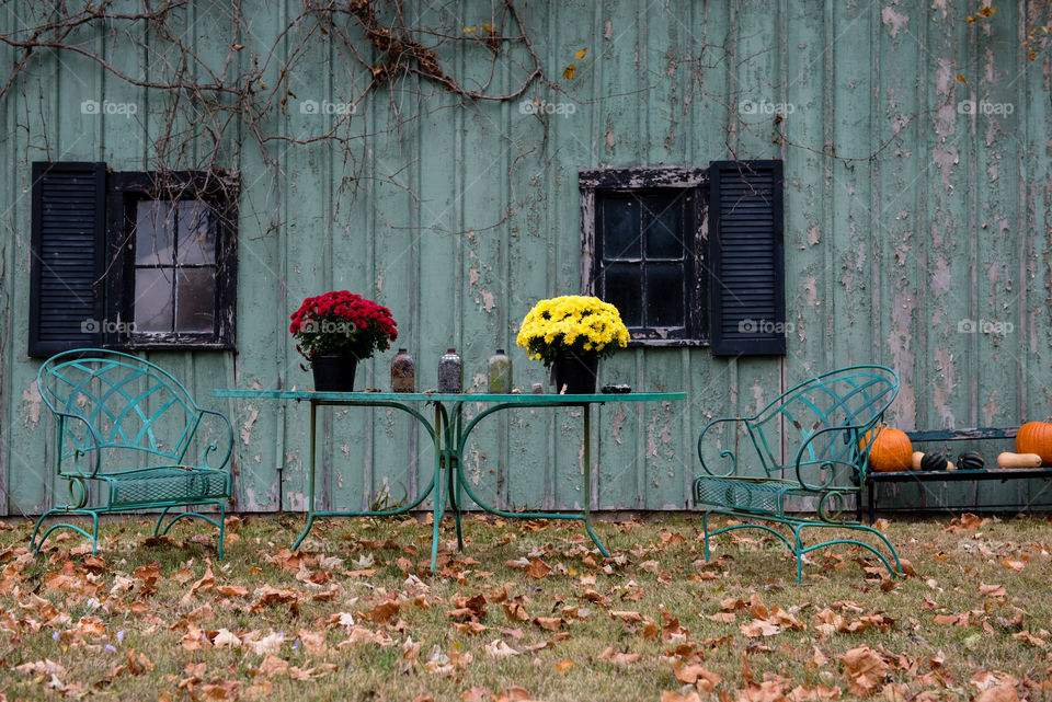 Teal barn in the countryside with outdoor table and chairs during the fall