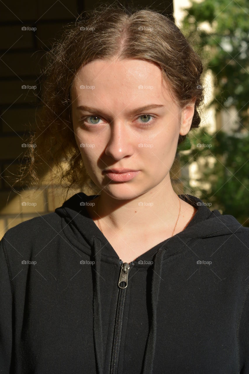 brunette girl beautiful portrait close up in sunlight outdoor brick wall background