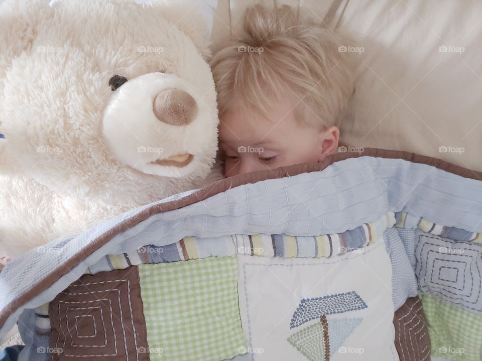 Little boy cuddling with teddy bear