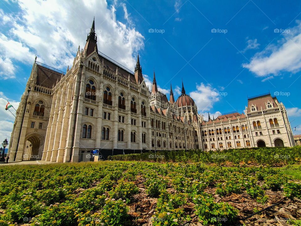 Panoramic view of the Hungarian parliament building in Budapest on a beautiful summer day with clear blue sky. Side panoramic view of the Hungarian parliament in Budapest.