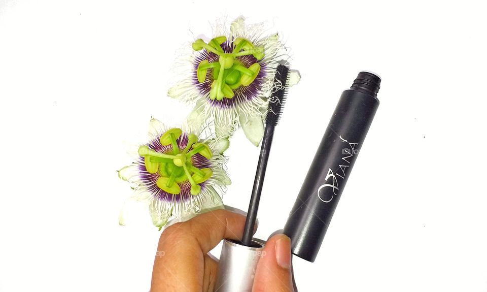 Viana mascara in a hand - beauty products with flowers